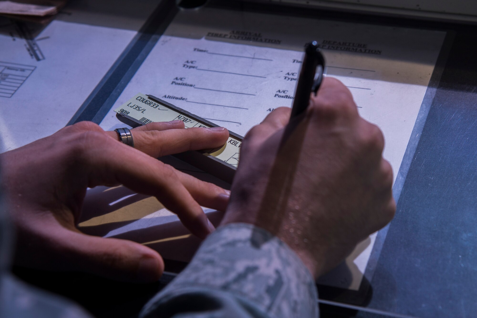 Senior Airman Anthony Carmignani, 375th Operational Support Squadron air traffic controller, writes out flight information including direction of takeoff, depart time, call signs, and type of aircraft on Aug. 9, 2016 at Scott Air Force Base, Ill. The strips help the air traffic controllers keep track of mulitple aircraft and are a reference for needed info during communications. (U.S. Air Force Photo by Airman Daniel Garcia)