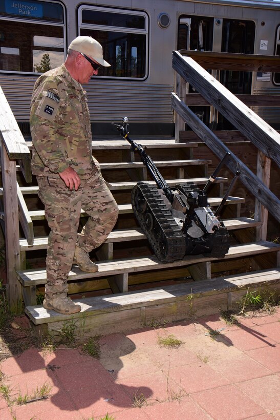Chief Master Sgt. Ed Smith, explosive ordnance disposal program manager with the Air National Guard's 115th Fighter Wing in Madison, Wis. monitors the progress of EOD specialists using a TALON tracked military robot to remotely inspect a simulated improvised explosive device during the Audacious Warrior exercise at Fort McCoy, Wis., July 27, 2017. The 12 day long exercise utilized the extensive training facilities of Volk Field Combat Readiness Training Center and Fort McCoy Total Force Training Center to provide EOD teams from eight different states comprehensive classroom and scenario based training in EOD tactics and procedures difficult to obtain at their respective home stations. (U.S. Air National Guard Photo by Master Sgt. Paul Gorman)