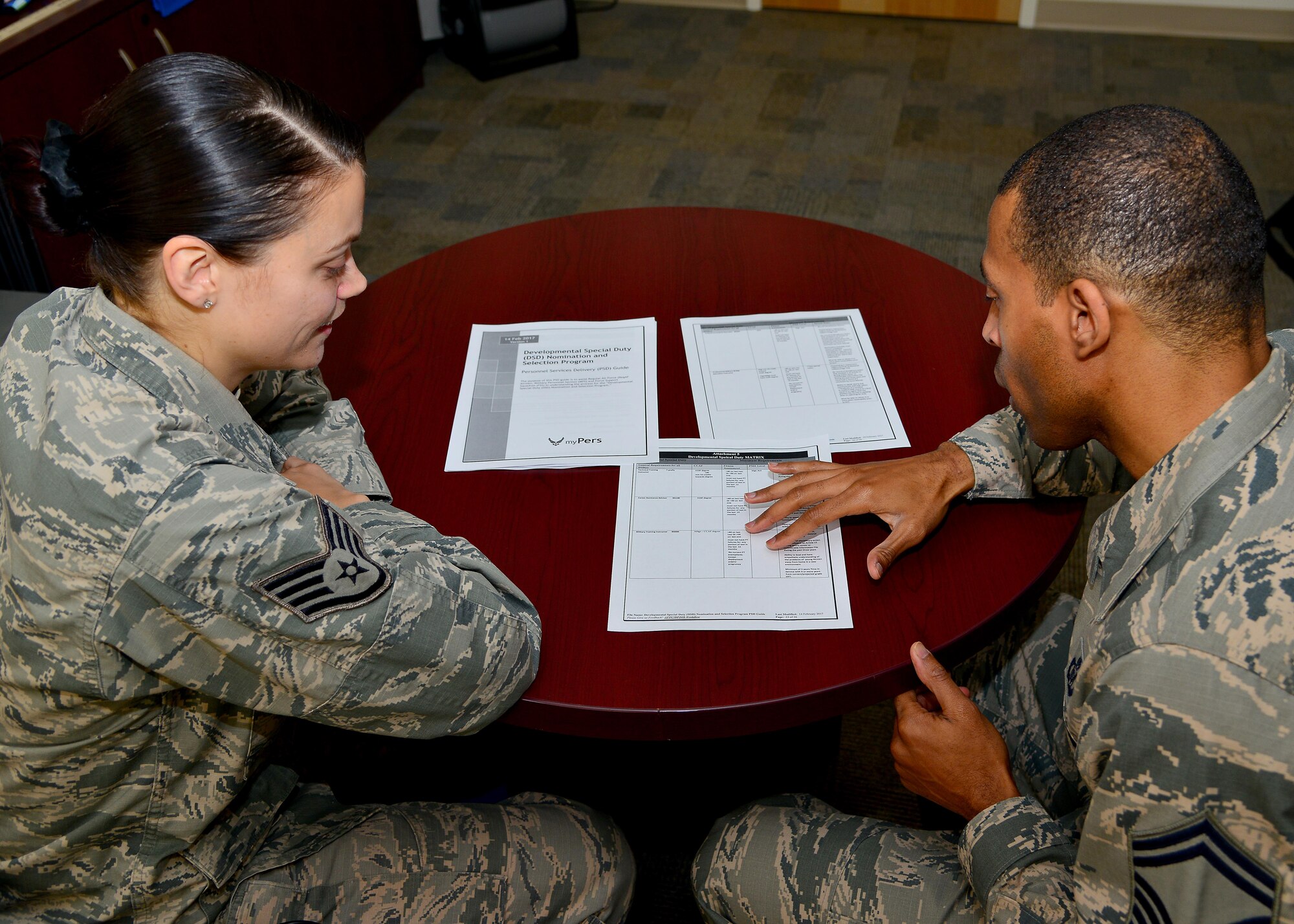 (From right) U.S. Air Force Senior Master Sgt. Michael Lee, 633rd Force Support Squadron career assistance advisor, speaks with Staff Sgt. Codi Walach, 633rd FSS First Term Airman Center team lead, about the options she has to become a military training instructor at Joint Base Langley-Eustis, Va., June 29, 2017. As a career advisor, Lee stays current on any new Air Force changes that could affect Developmental Special Duty processes.