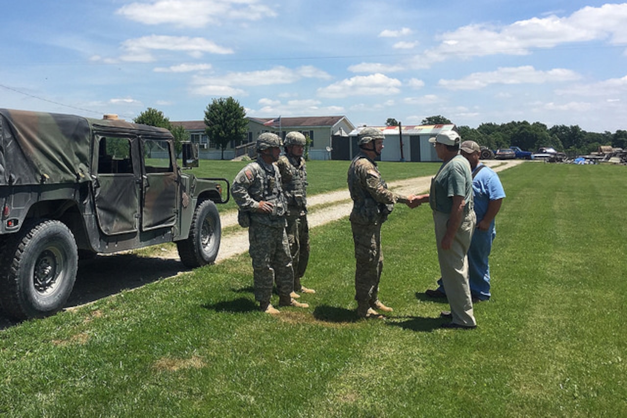 Army Lt. Col. Andrew Bates, commander of the Kentucky Army National Guard’s 2nd Battalion, 138th Field Artillery Brigade, thanks Robert Allen Jones Sr. for his family's cooperation in the battalion's signal operations, June 10, 2017. Army photo
