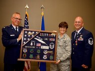 Airmen of the 932nd Airlift Wing paid special final tributes to Master Sgt. Gerald Sonnenberg (far right) on the occasion of his retirement July 9, 2017, from the United States Air Force Reserve. The event included a Meritorious Service Medal for his recent history office service and 50 year history video, which ends culminating a very distinguished 31 year military career.  932nd Chief of Public Affairs, Lt. Col. Stan Paregien and 932nd Director of Staff, Lt. Col. Julie Novy, presented this historical shadow box, which encapsulates his three decades long career from law enforcement to public affairs to the history office.  The whistle in the box represents law enforcement while the pen quill represents Sgt. Sonnenberg's writing skills in public affairs stories.  (U.S. Air Force photo by Tech. Sgt. Christopher Parr)