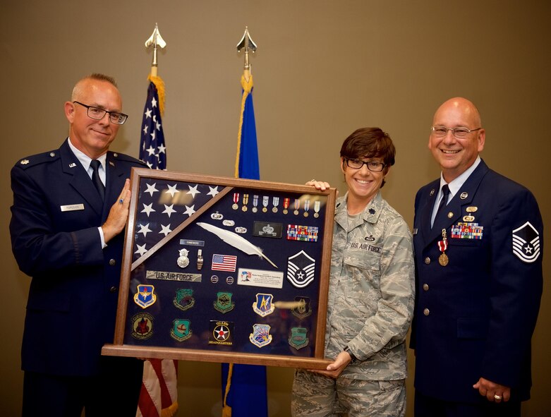 Airmen of the 932nd Airlift Wing paid special final tributes to Master Sgt. Gerald Sonnenberg (far right) on the occasion of his retirement July 9, 2017, from the United States Air Force Reserve. The event included a Meritorious Service Medal for his recent history office service and 50 year history video, which ends culminating a very distinguished 31 year military career.  932nd Chief of Public Affairs, Lt. Col. Stan Paregien and 932nd Director of Staff, Lt. Col. Julie Novy, presented this historical shadow box, which encapsulates his three decades long career from law enforcement to public affairs to the history office.  The whistle in the box represents law enforcement while the pen quill represents Sgt. Sonnenberg's writing skills in public affairs stories.  (U.S. Air Force photo by Tech. Sgt. Christopher Parr)