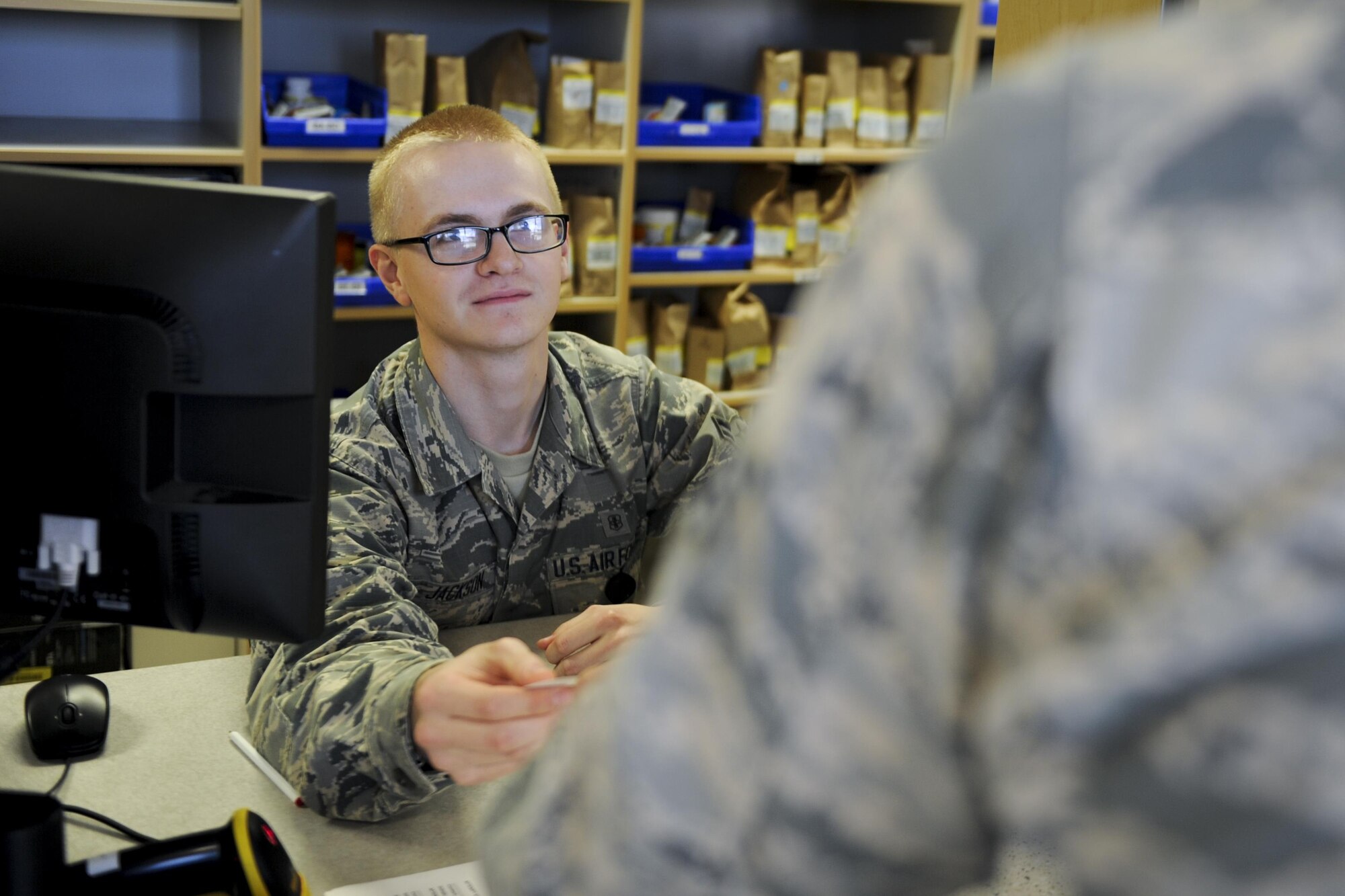 Airman 1st Class Gavin Jackson, a pharmacy technician with the 1st Special Operations Medical Group, gives a patient a third party collection verification card at Hurlburt Field, Fla., July 11, 2017. TPC verification cards verify a patient’s updated medical insurance information to ensure Hurlburt’s Air Commandos are eligible for prescription medications. (U.S. Air Force photo by Airman 1st Class Dennis Spain)