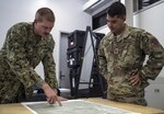 A U.S. Navy Helicopter Sea Combat Squadron-85 intelligence analyst points out locations on a map of Central Queensland in Australia to a U.S. Air Force 1st Special Operations Squadron intelligence officer, as the analysts build the intelligence picture for the warfighting scenario of Talisman Saber 2017, July 10, 2017 at Rockhampton, Australia. Aside from service components working with the Australian military, the exercise also provided an opportunity for U.S. forces to integrate intelligence systems and share tactics, trainings and procedures with other U.S. services. 