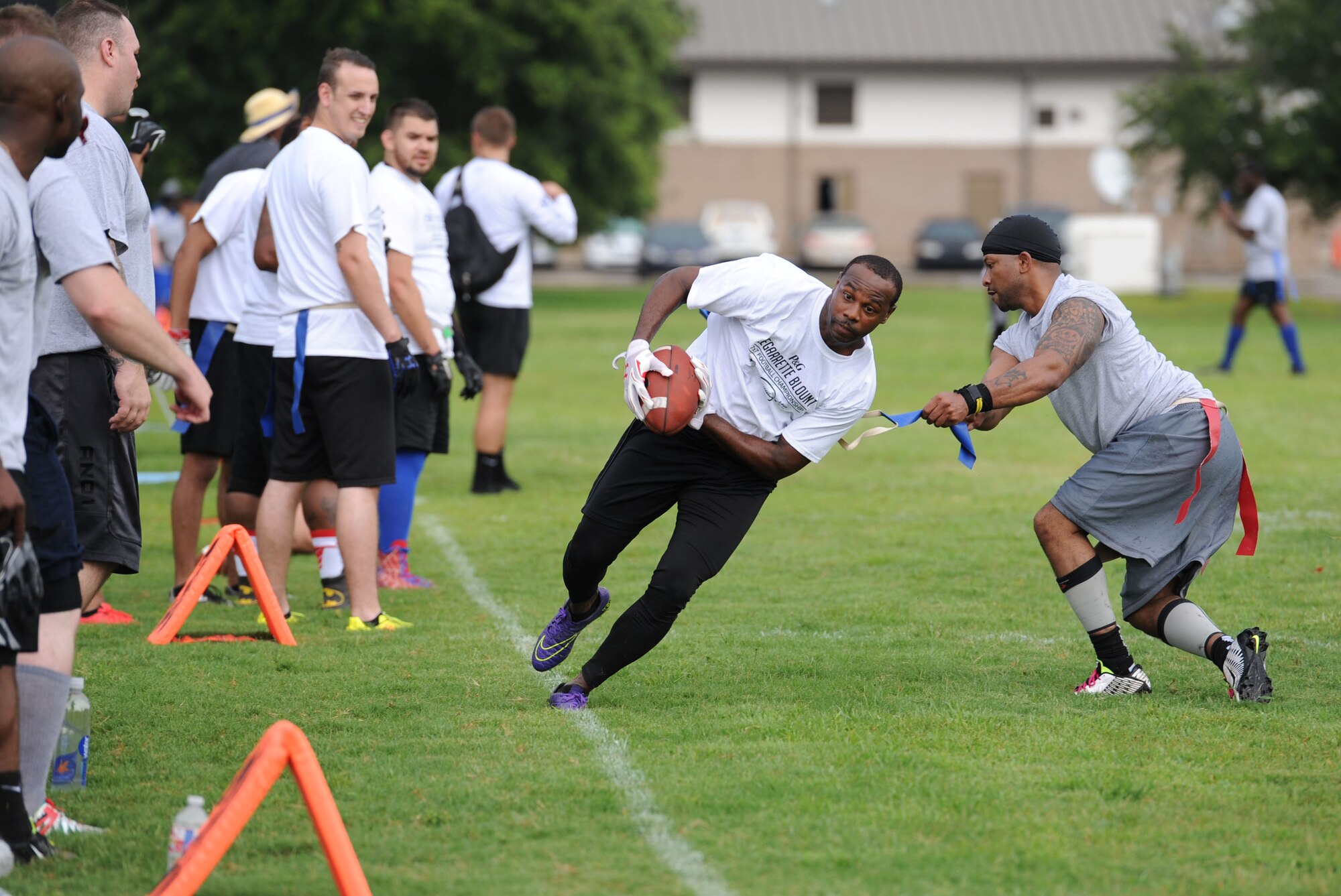 Master Sgt. Andre Perry, 334th Training Squadron air traffic control superintendent, grabs a flag from Master Sgt. Glenn Davis, 335th TRS personnel apprentice course NCO in charge, during the P&G LeGarrette Blount 7x7 Football Championship July 8, 2017, on Keesler Air Force Base, Miss. Blount, Philadelphia Eagles National Football League running back, hosted the two-day camp consisting of 10 flag football teams from Keesler and the local community to promote the importance of living an active and healthy lifestyle. (U.S. Air Force photo by Kemberly Groue) 