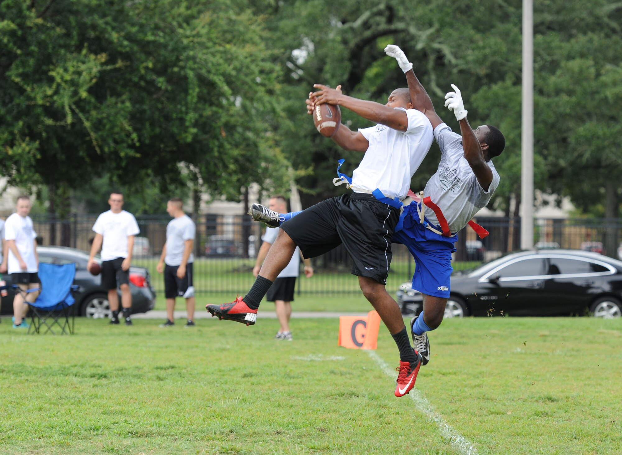 Staff Sgt. Zerrick Haymond, 81st Security Forces Squadron patrolman, and Bryant Lavender, Coast Liners team member, leap for the ball during the P&G LeGarrette Blount 7x7 Football Championship July 8, 2017, on Keesler Air Force Base, Miss. Blount, Philadelphia Eagles National Football League running back, hosted the two-day camp consisting of 10 flag football teams from Keesler and the local community to promote the importance of living an active and healthy lifestyle. (U.S. Air Force photo by Kemberly Groue) 
