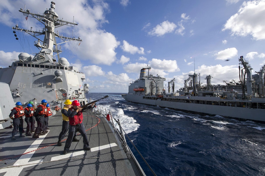 Navy Petty Officer 1st Class Matthew James fires a shot line from the guided-missile destroyer USS Sterett to the fleet replenishment oiler USNS John Ericsson for an underway replenishment in the Coral Sea, July 10, 2017, during exercise Talisman Saber 17. Talisman Saber is a biennial U.S.-Australia exercise designed to achieve interoperability and strengthen the nations’ alliance. Navy photo by Petty Officer 1st Class Byron C. Linder