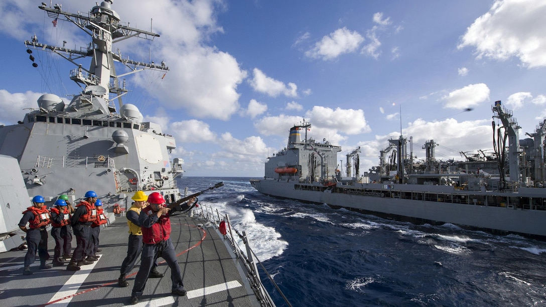 Navy Petty Officer 1st Class Matthew James fires a shot line from the guided-missile destroyer USS Sterett to the fleet replenishment oiler USNS John Ericsson for an underway replenishment in the Coral Sea, July 10, 2017, during exercise Talisman Saber 17. Talisman Saber is a biennial U.S.-Australia exercise designed to achieve interoperability and strengthen the nations’ alliance. Navy photo by Petty Officer 1st Class Byron C. Linder
