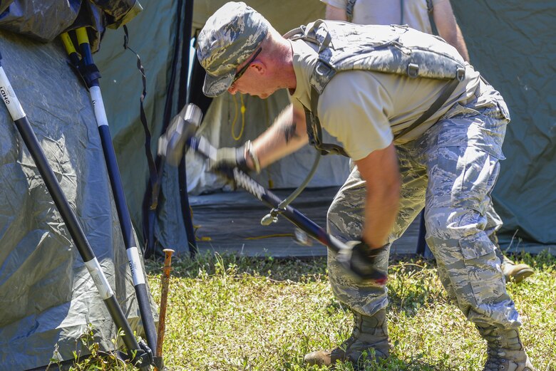 U.S. Air Force Staff Sgt. Robert Joyce, 644th Combat Communications Squadron cyber transport technician, constructs a tent during exercise Dragon Forge June 12, 2017. Day one of the training exercise started with the 644th CBCS team being tasked with setting up a forward operating base with concertina wire around the perimeter. (U.S. Air Force photo by Airman 1st Class Christopher Quail)