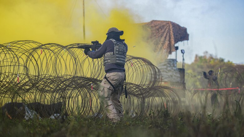 A U.S. Airman, acting as an opposing force, fires paintball rounds at 644th Communications Squadron Airmen during exercise Dragon Forge June 15, 2017, at Andersen South, Guam. Opposing forces repeatedly attacked the base throughout the day prior to an all-out final attack from all sides with the goal of overrunning the base. (U.S. Air Force photo by Airman 1st Class Christopher Quail)