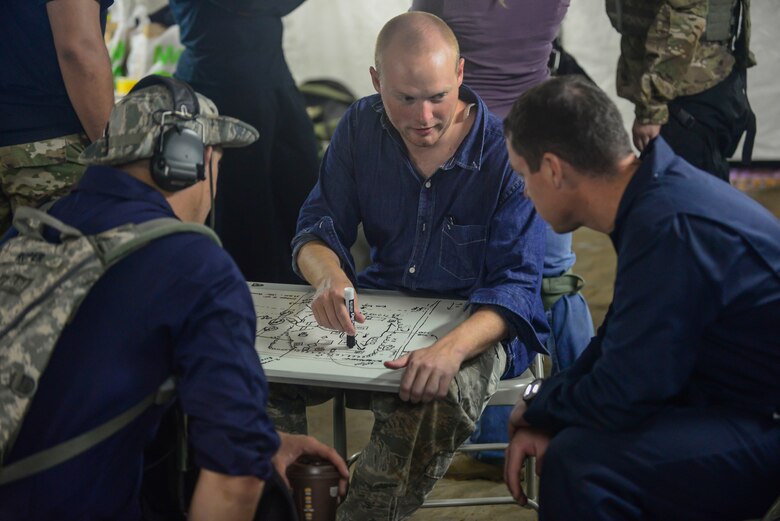 U.S. Air Force Airmen from the 644th Combat Communications Squadron acting as cadres and opposing force coordinates an attack on a map during exercise Dragon Forge June 15, 2017, at Andersen South, Guam. Exercise Dragon Forge is a 164-hour training exercise designed to teach, train and build combat skills, while instilling the warrior ethos into CBCS Airmen. (U.S. Air Force photo by Airman 1st Class Christopher Quail)