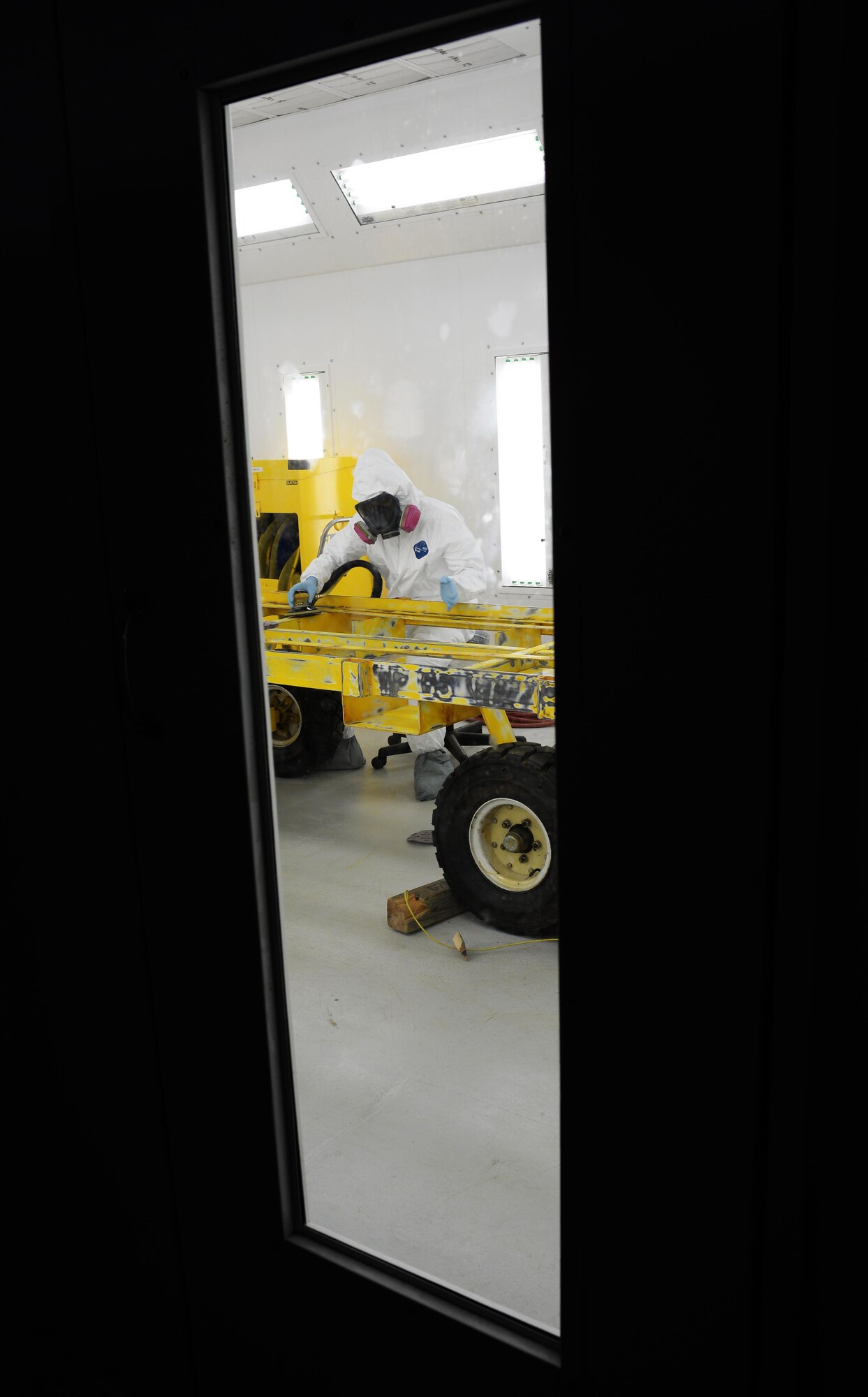 Senior Airman Jeremy Washington, 374th Maintenance Squadron aircraft structural journeyman, deployed from Yokota Air Base, Japan, sands down a weapons trailer in the new temporary corrosion control facility June 29, 2017, at Andersen Air Force Base, Guam. The new permanent facility is currently being built and will have air showers, transition rooms, red to green zones for contamination, and different kinds of air conditioners with separate units in each zone as to not contaminate other zones. (U.S. Air Force photo by Senior Airman Alexa Ann Henderson