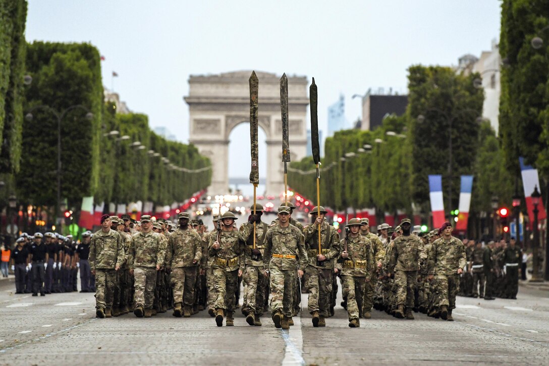 Almost 200 U.S. soldiers, sailors, Marines and airmen march from the Arc de Triomphe in Paris.
