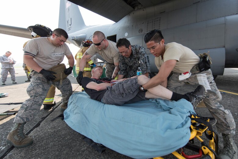 First responders from the Japan Air Self-Defense Force and U.S. Air Force move a simulated aircraft accident victim onto a stretcher during a major accident response exercise at Yokota Air Base, Japan, July 10, 2017. This is the first time Japanese hospital personnel and Japan Air Self-Defense Force members participated in a MARE, ensuring they are ready for any aircraft emergency. (U.S. Air Force photo by Yasuo Osakabe)