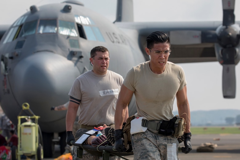 Senior Airman Richson Bacay and SrA Jonathan Rodriguez, both 374th Medical Operations Squadron aerospace medical technicians, carry a simulated aircraft accident victim to safety during a major accident response exercise at Yokota Air Base, Japan, July 10, 2017. The MARE is an annual training requirement for the base to test its readiness and response capabilities. (U.S. Air Force photo by Yasuo Osakabe)