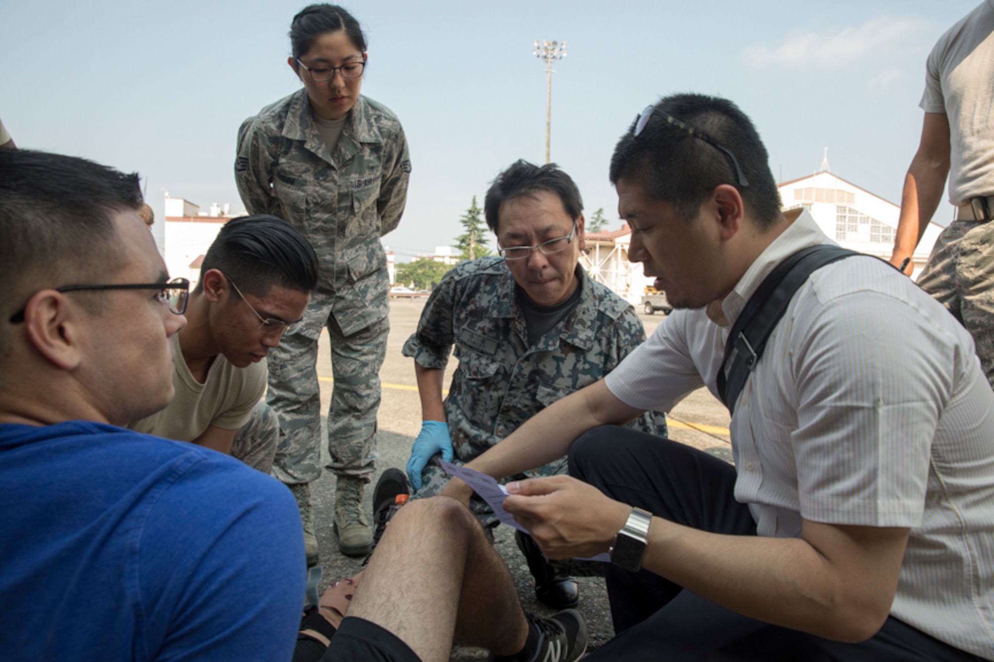 First responders from the Kyorin University Hospital, Japan Air Self-Defense Force Air Defense Command and U.S. Air Force Senior Airman Richson Bacay, 374th Medical Operations Squadron aerospace medical technician, work together to aid a simulated aircraft accident victim during a major accident response exercise (MARE), at Yokota Air Base, Japan, July 10, 2017. During a MARE all simulated medical injuries and victims are treated as real by firefighters and medical airmen adding the importance of urgency to the training. (U.S. Air Force photo by Yasuo Osakabe)