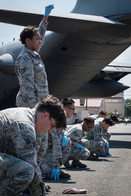 Staff Sgt. Ashli Phillips-Nixon, 374th Force Support Squadron front desk rep, gives a signal after having found a simulated body part during a major accident response exercise, June 10, 2017, at Yokota Air Base, Japan. The exercise helps Airmen respond to a crisis situation they may face during a large casualty accident. (U.S. Air Force photo by Airman 1st Class Juan Torres)