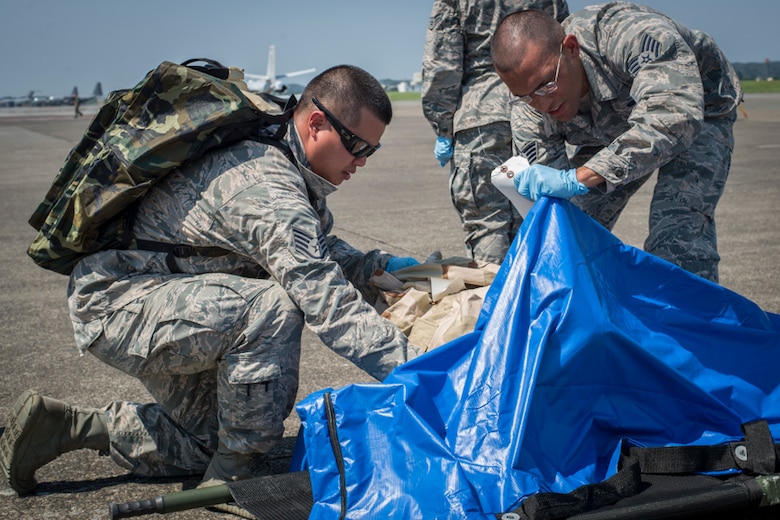 Staff Sgt. Johnny Liu, left, and Staff Sgt. Kenny Bradley, 374th Force Support Squadron search and recovery team members, process simulated body parts found scattered during a major accident response exercise, June 10, 2017, at Yokota Air Base, Japan. The exercise is designed to test a wing’s ability to respond to a variety of different events that could be disastrous to the installation and negatively impact the mission. (U.S. Air Force photo by Airman 1st Class Juan Torres)
