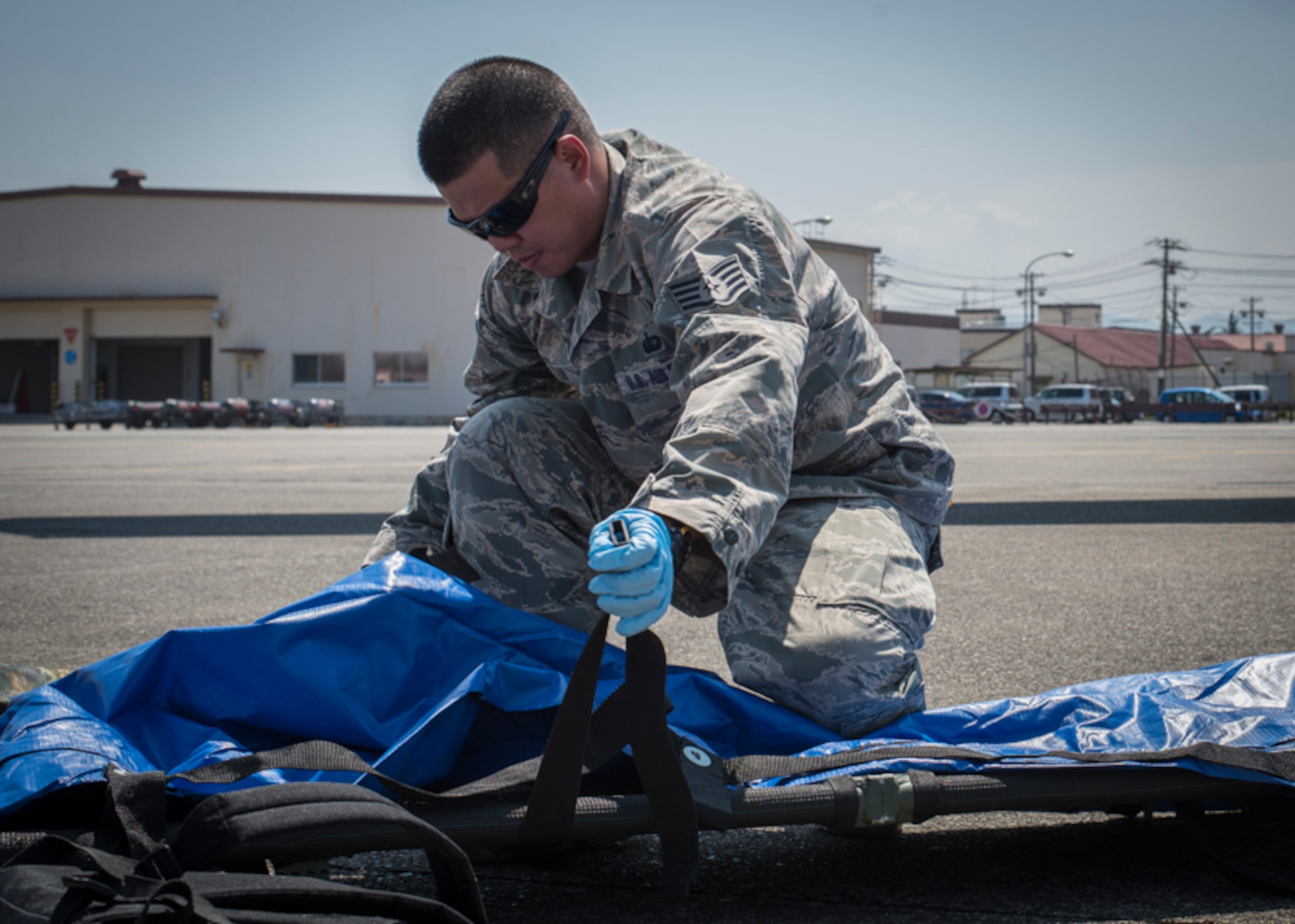 Staff Sgt. Johnny Liu, 374th Force Support Squadron search and recovery team member, prepares a litter for use during a major accident response exercise, June 10, 2017, at Yokota Air Base, Japan. The training helps Airmen respond to a crisis situation they may face during a large casualty accident. (U.S. Air Force photo by Airman 1st Class Juan Torres)