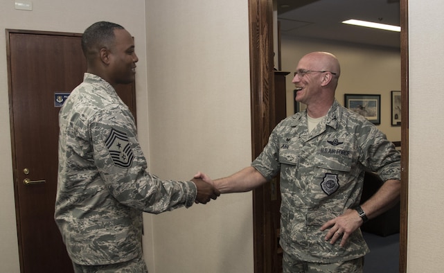 U.S. Air Force Chief Master Sgt. Anthony Johnson, left, the Pacific Air Forces' command chief, shakes hands with Col. R. Scott Jobe, the 35th Fighter Wing commander, right, during a visit at Misawa AIr Base, Japan, July 11, 2017. During his tour, Johnson met with various shops and organizations while sharing his goals for improving PACAF's enlisted force so they can work at their optimal level. (U.S. Air Force photo by Airman 1st Class Sadie Colbert)