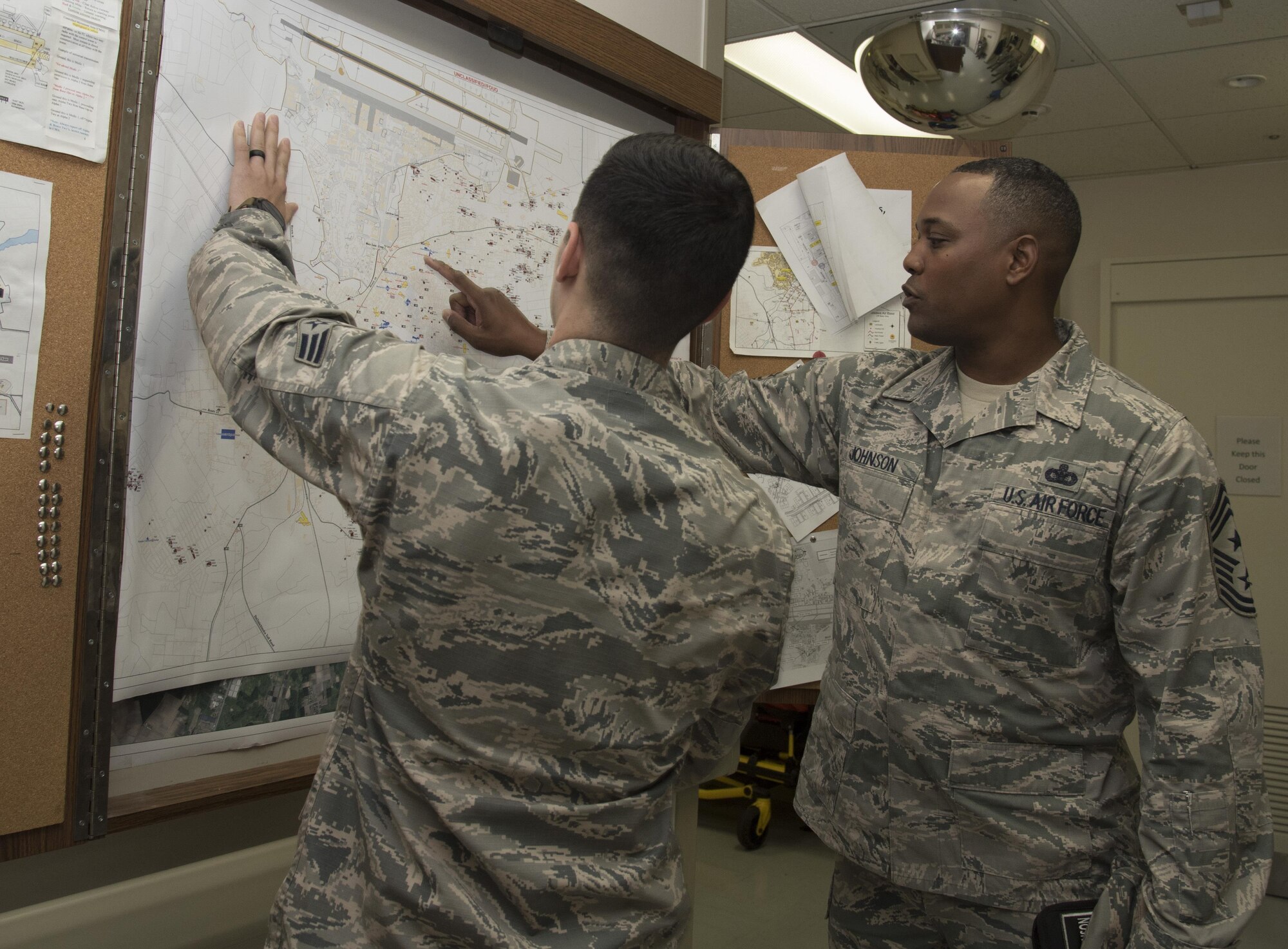 U.S. Air Force Senior Airman Dylan Gorr, left, a 35th Medical Operations Squadron aerospace medical service technician, looks at a map of Misawa City, Japan, with Chief Master Sgt. Anthony Johnson, the Pacific Air Forces' command chief, during his tour at Misawa Air Base, Japan, July 11, 2017. During the visit, Airmen explained their current capabilities as well as the challenges they face in their career. (U.S. Air Force photo by Airman 1st Class Sadie Colbert)