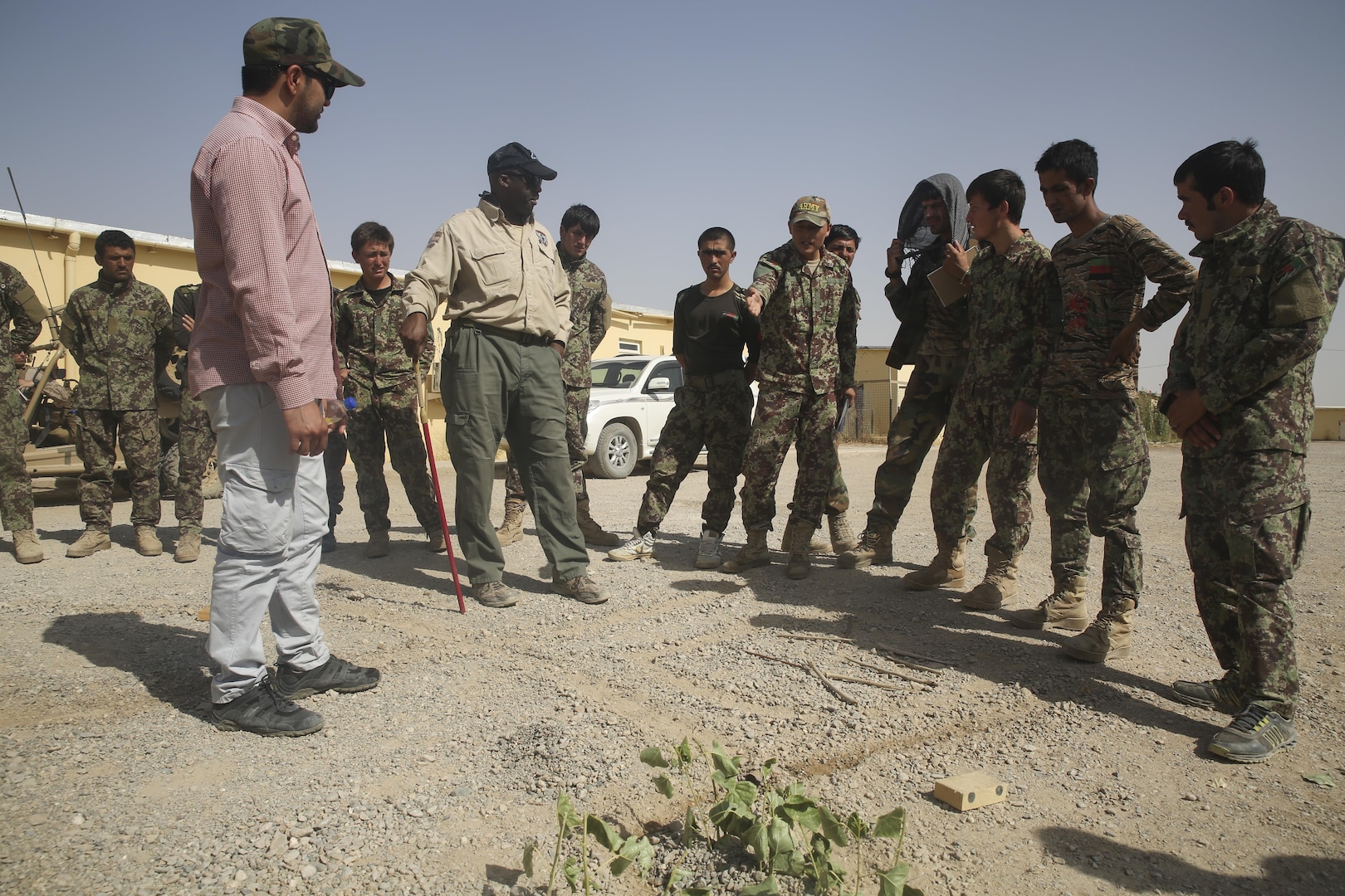 An Afghan National Army soldier with 215th Corps indicates a possible location for an improvised explosive device using a terrain model at Camp Shorabak, Afghanistan, July 13, 2017. Approximately 70 engineer soldiers with various units from the 215th Corps recently began a route clearance course, an eight-week training cycle designed to enhance their counter IED skills and help promote maneuverability throughout the region. (U.S. Marine Corps photo by Sgt. Lucas Hopkins)