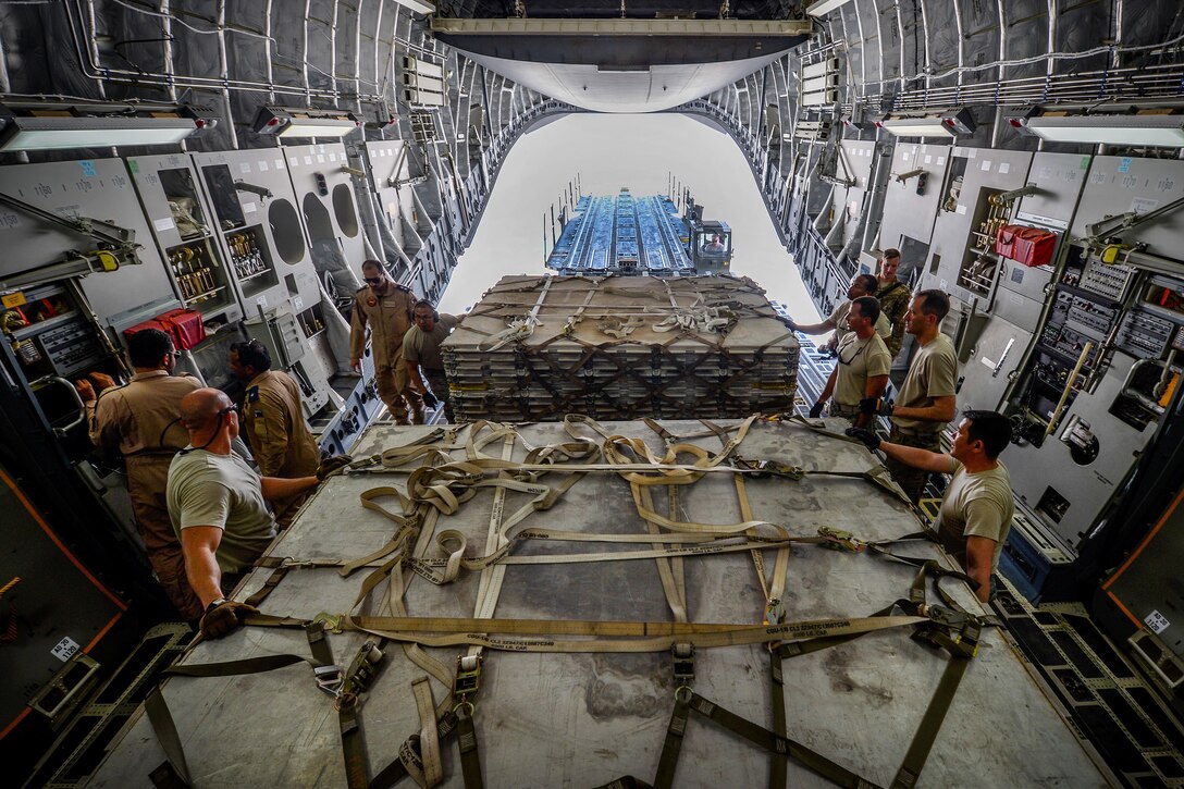 U.S. airmen load equipment and supplies onto a Qatari air force C-17 Globemaster III at Al Udeid Air Base, Qatar, July 2, 2017, for a mission supporting Operation Inherent Resolve. The airmen are loadmasters assigned to the 8th Expeditionary Air Mobility Squadron. Air Force photo by Staff Sgt. Michael Battles