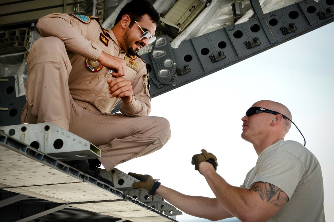 A U.S. airman, right, speaks with a Qatari airman during the loading of a Qatari C-17 Globemaster III at Al Udeid Air Base, Qatar, July 2, 2017, for a mission supporting Operation Inherent Resolve. Air Force photo by Staff Sgt. Michael Battles