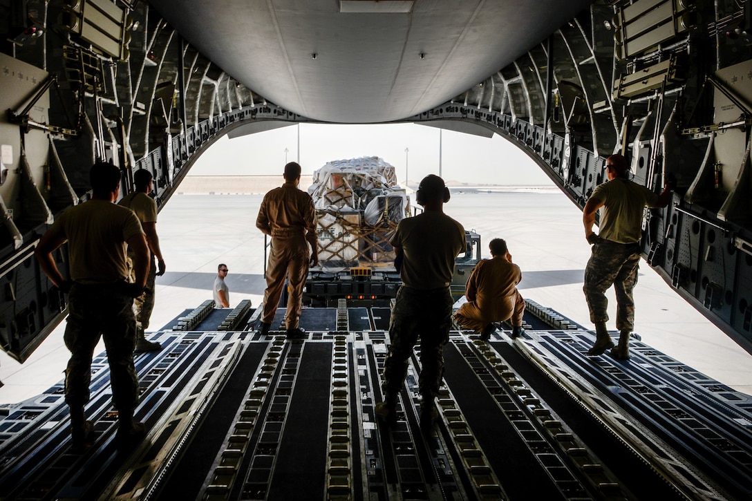 U.S. and Qatari airmen prepare to load equipment and supplies into a Qatari air force C-17 Globemaster III aircraft at Al Udeid Air Base, Qatar, July 2, 2017, for a mission supporting Operation Inherent Resolve. Air Force photo by Staff Sgt. Michael Battles