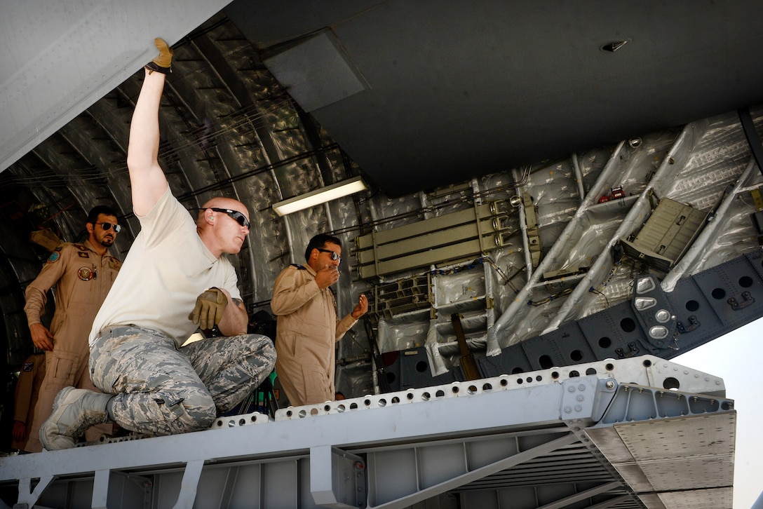 A Qatari airman, right, directs a forklift operator while loading pallets of equipment and supplies into a Qatari air force C-17 Globemaster III at Al Udeid Air Base, Qatar, July 2, 2017, before a mission supporting Operation Inherent Resolve. Air Force photo by Staff Sgt. Michael Battles