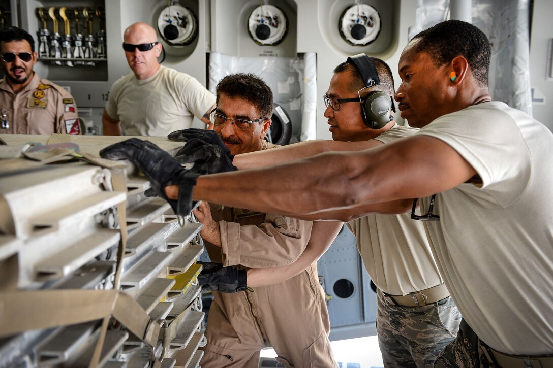 U.S. and Qatari airmen push a pallet of equipment and supplies into a Qatari air force C-17 Globemaster III at Al Udeid Air Base, Qatar, July 2, 2017, before a mission supporting Operation Inherent Resolve. Air Force photo by Staff Sgt. Michael Battles