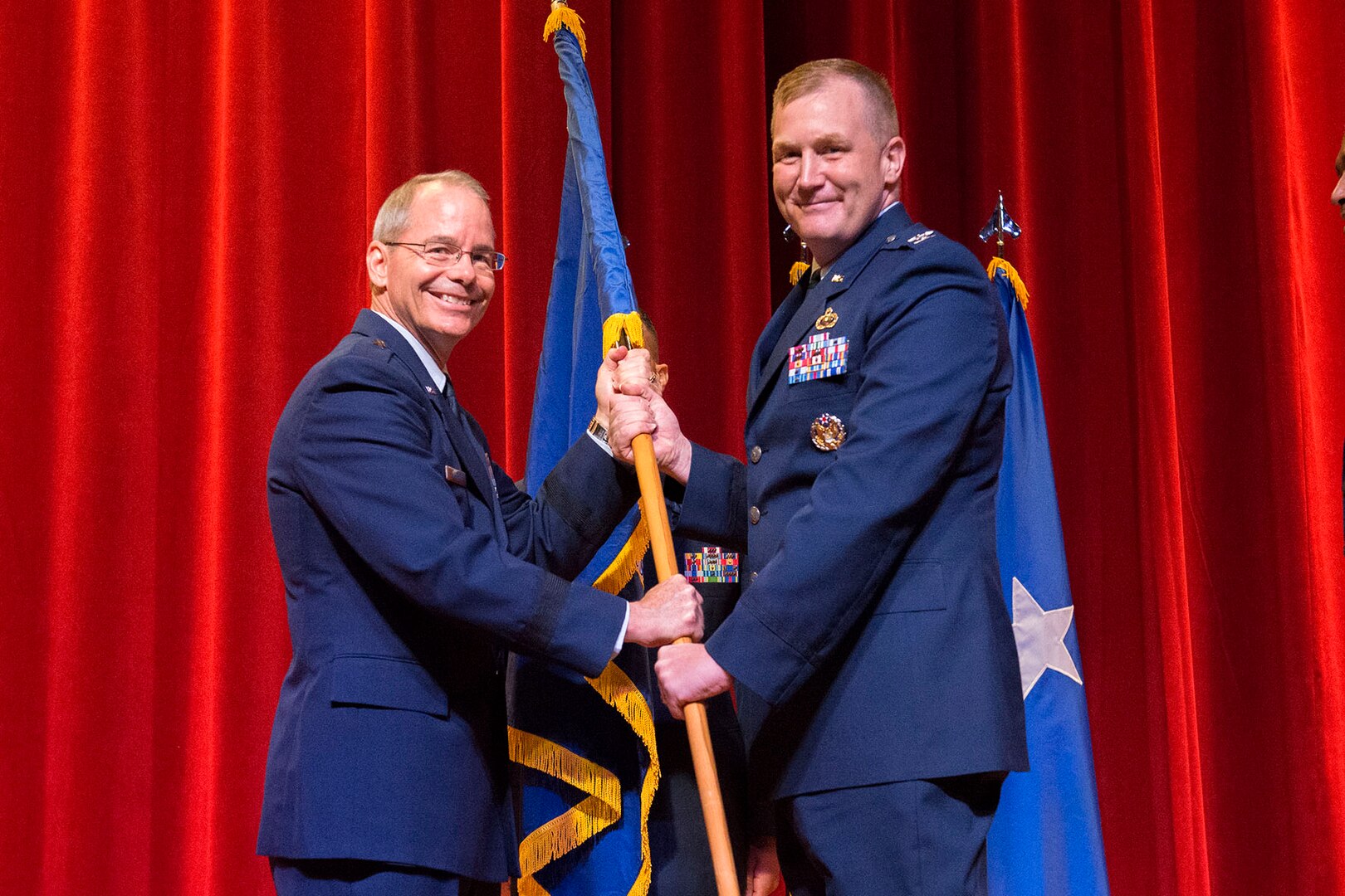 Col. Jonathan Wright accepts the guidon and command of the 502nd Installation Support Group from Brig. Gen. Bob LaBrutta, 502nd Air Base Wing and Joint Base San Antonio commander, during a change of command ceremony June 6, 2016 at the Bob Hope Theatre at JBSA-Lackland. Wright was previously the 502nd Contracting Squadron commander. 