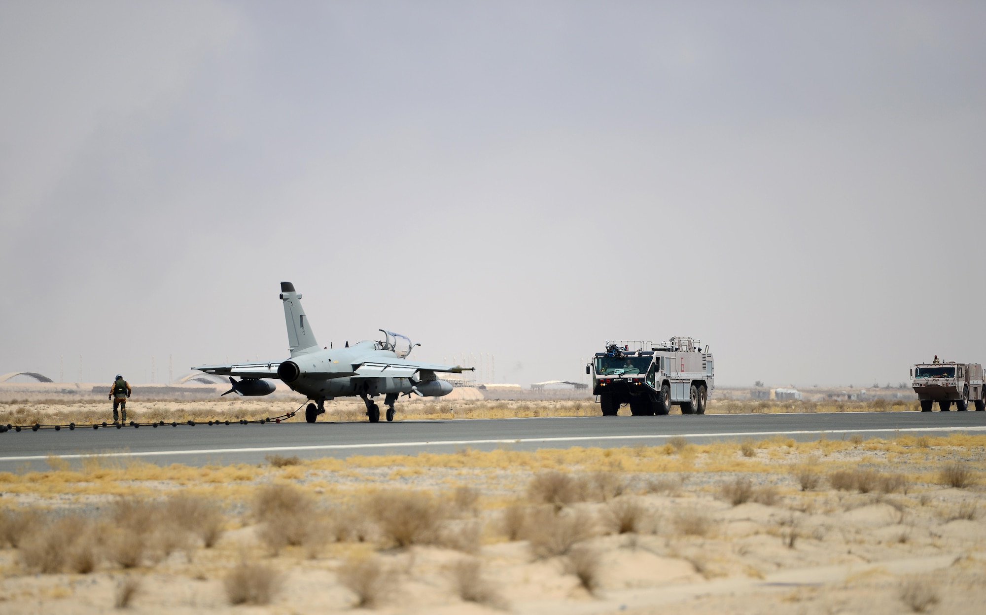 U.S. Air Force fire fighters assigned to the 407th Expeditionary Civil Engineer Squadron, respond to an aircraft distress call during an Aircraft Arresting System engagement with an Italian Air Force AMX A-11 Ghibli aircraft in Southwest Asia on July 3, 2017. The 407th ECES fire department operate as first responders to all U.S. and coalition aircraft in the area of responsibility. (U.S. Air Force photo by Tech. Sgt. Andy M. Kin)