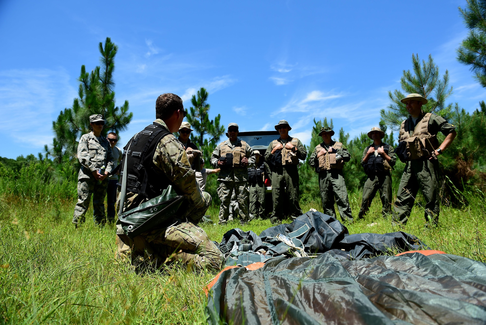 A survival, evasion, resistance and escape specialist, SERE augmentees, pilots, and weapons systems officers from Seymour Johnson Air Force Base, North Carolina, discuss a plan of action after ejecting from an aircraft during a combat survival training course, June 27, 2017, at Howell Woods, Four Oaks, North Carolina. Pilots and WSO’s are required to recertify their CST and water survival training courses every three years. (U.S. Air Force photo by Airman 1st Class Kenneth Boyton)