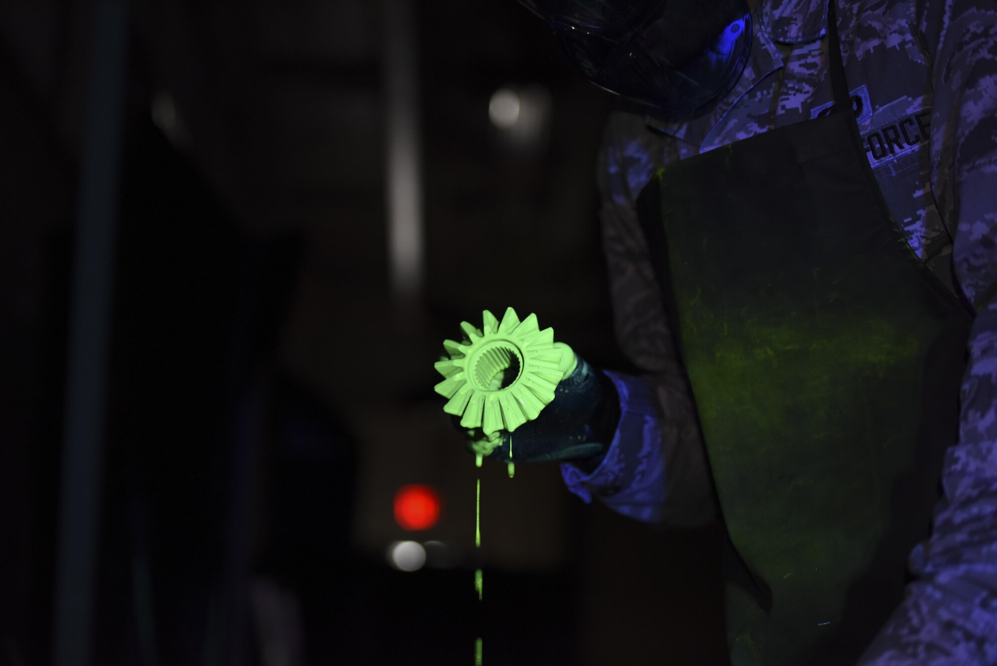 Senior Airman Brett Gyurnek, 437th Maintenance Squadron Non-Destructive Inspection technician, retrieves a core reverser gear from a vat of fluorescent penetrant during a deficiency inspection at Joint Base Charleston, S.C. July 10, 2017. Fluorescent penetrant testing is a reliable way to illuminate fractures on the surface of damaged aircraft parts. It is done by submerging the part in a fluorescent liquid and allowing the dye to penetrate into any cracks. The liquid is then rinsed off and placed in a developing agent which makes the fluorescent liquid illuminate brighter under an ultraviolet light. The part is then placed under an ultraviolet light and, if cracks are present, they will light up making the deficiency more visible.