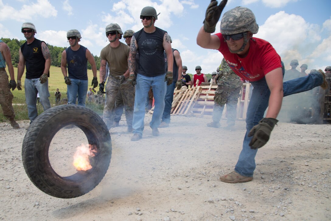 A soldier role-plays as a hostile civilian by throwing a tire while conducting a crowd riot control scenario during a Kosovo Force mission rehearsal exercise at the Joint Multinational Readiness Center in Hohenfels, Germany, July 5, 2017. The soldier is assigned to the Oklahoma National Guard. Army photo by Spc. Randy Wren