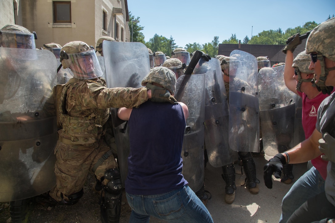 Soldiers suppress simulated hostile civilians while conducting a riot control scenario during a Kosovo Force mission rehearsal exercise at the Joint Multinational Readiness Center in Hohenfels, Germany, July 6, 2017. The soldiers are assigned to the 82nd Airborne Division, 3rd Battalion, 319th Field Artillery Regiment. Army photo by Spc. Randy Wren




