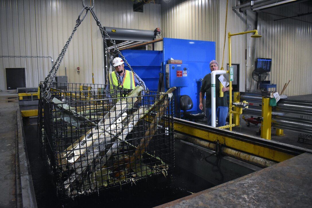 Chad McLeod, area engineer, South Alabama Area Office, observes as a load of Army equipment is pulled out of a chemical vat at a newly-renovated building at Anniston Army Depot. In addition to replacing and improving the chemical vat area, contractors also made HVAC and plumbing upgrades, along with electrical improvements. 