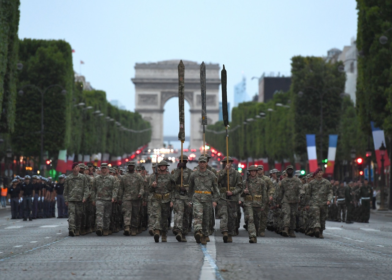 Almost 200 U.S. soldiers, sailors, Marines and airmen assigned to units in Europe and the 1st Infantry Division based at Fort Riley, Kansas, march from the Arc de Triomphe to the Place de la Concorde during a July 12 rehearsal for the military parade on Bastille Day to be held in Paris, July 14, 2017. Navy photo by Chief Petty Officier Michael McNabb