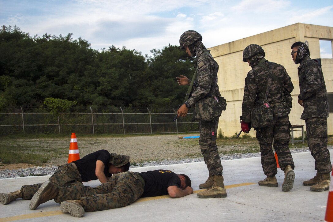 U.S. Marine Corps Lance Cpl. Andres R. Delgado, left, and Lance Cpl. John E. Cimmerman, right, military police, simulate neighbors affected by an unknown chemical substance during an exercise in Pohang, South Korea, July 3, 2017. Marine Corps photo by Lance Cpl. Andy Martinez