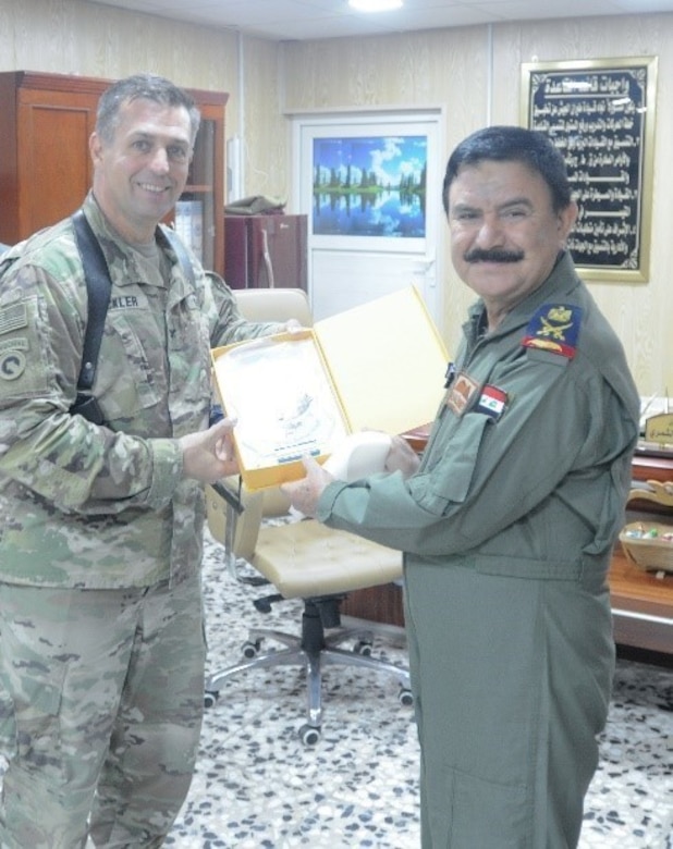 CAMP TAJI, Iraq - U.S Army Col. Mark Beckler, 29th Combat Aviation Brigade commander, is presented with a plaque by Iraqi Maj. Gen. Khalid Al Shimry, the new aviation base commander of Camp Taji Military Complex, at Camp Taji Military Complex, Iraq, July 6, 2017. The 29th CAB is an Army National Guard unit that is currently deployed in support of Combined Joint Task Force - Operation Inherent Resolve. CJTF-OIR is the global Coalition to defeat ISIS in Syria and Iraq.  (U.S. Army Photo by Capt. Stephen James)