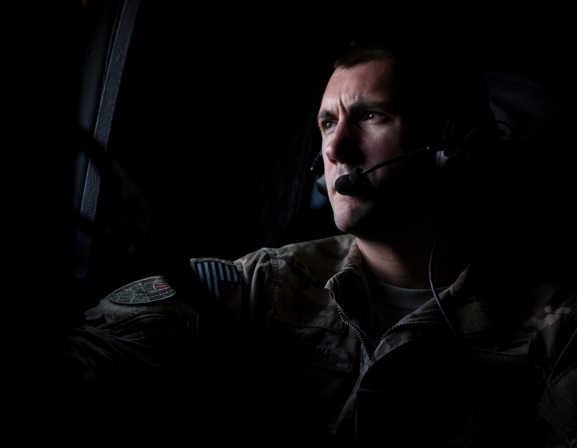 Staff Sgt. Jeremy Wolski, a loadmaster with the 15th Special Operation Squadron, looks out the paratroop door window of an MC-130H Combat Talon II while flying to Total Force Exercise 17-3, over Louisville, Ky., July 8, 2017. The Total Force Exercise enhances 1st Special Operations Wing Air Commandos' interoperability with other units and services. (U.S. Air Force photo by Tech. Sgt. Jeffrey Curtin)