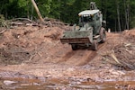 Wisconsin National Guard troops are mobilized to assist three flood-stricken communities. In this photo from Aug. 9, 2016, a Guard front loader clears debris from the Oronto Creek in Iron County, Wis.