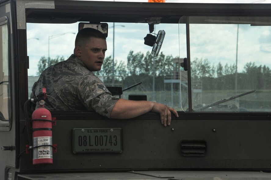Senior Airman Luke Ryan, 705th Munitions Squadron special purpose vehicle operator, backs up a “tug” at Minot Air Force Base, N.D., June 30, 2017. The “tug” is used to maneuver rotary launchers to-and-from the B-52H Stratofortress. (U.S. Air Force photo by Airman 1st Class Jessica Weissman)