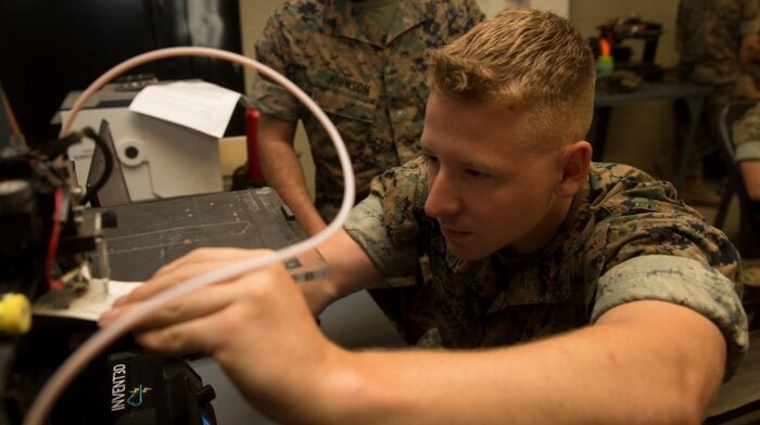 A Marine calibrates a three-dimensional printer during the 3-D Printing Training Course at Marine Corps Base Camp Lejeune, North Carolina. Marines have been embracing 3-D printing for several years now, and there are more than 40 units using 3-D printers in the field to build drones, buildings, vehicles and other items out of various materials. (U.S. Marine Corps photo by Sgt. Ian Leones) 