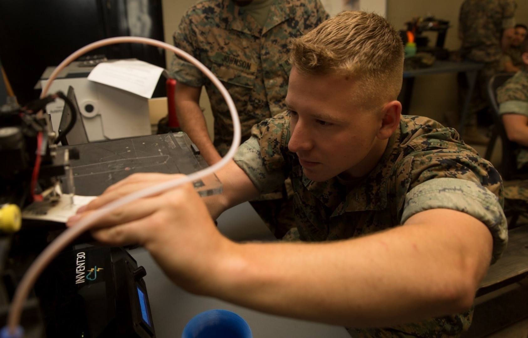 A Marine calibrates a three-dimensional printer during the 3-D Printing Training Course at Marine Corps Base Camp Lejeune, North Carolina. Marines have been embracing 3-D printing for several years now, and there are more than 40 units using 3-D printers in the field to build drones, buildings, vehicles and other items out of various materials. (U.S. Marine Corps photo by Sgt. Ian Leones) [High-resolution photo]