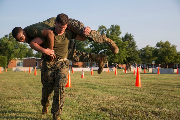 Cpl. Russell Evans, servers and services noncommissioned officer, Data and Communications, U.S. Marine Corps Forces Command, fireman carries Lance Cpl. Chad Mexile as they transition to the next exercise during MARFORCOM’s morning physical training session at Camp Allen, Norfolk, Va., July 13. This unit PT was focused on combat fitness with the Marines running multiple 880-meter sprints, ammo-can lifts, fireman carries, buddy drags, low and high crawls, and squad push-ups. (Official U.S. Marine Corps photo by Cpl. Logan Snyder/ Released)