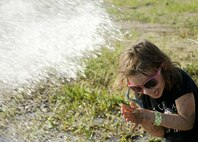 A child is hosed off after participating in the 2017 Mud Like You Mean It race at Minot Air Force Base, N.D., July 7, 2017. Approximately 600 Airmen and their families attended the event, which lasted two hours. (U.S. Air Force photo by Senior Airman Sahara L. Fales)