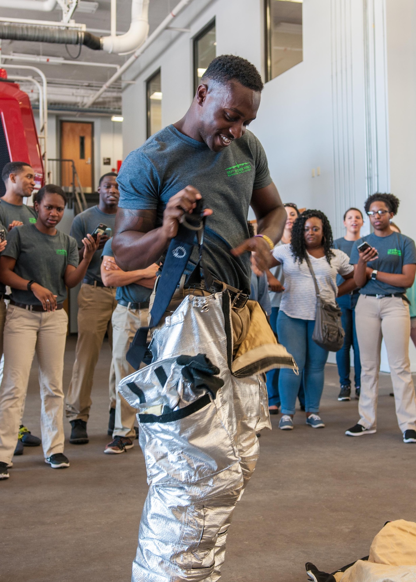 Deshon Watson races to put on all of the gear required for a firefighter in the Air Force during a base tour on Barksdale Air Force Base, La. July 9, 2017. Watson is a part of the Development and Training Flight of the Reserve 307th Bomb Wing who participated in a base tour along with family and friends. After attending Basic Military Training, he will continue on to train to be a firefighter for the 307th Civil Engineer Squadron on Barksdale. (U.S. Air Force photo by Tech. Sgt. Cody Burt/Released)