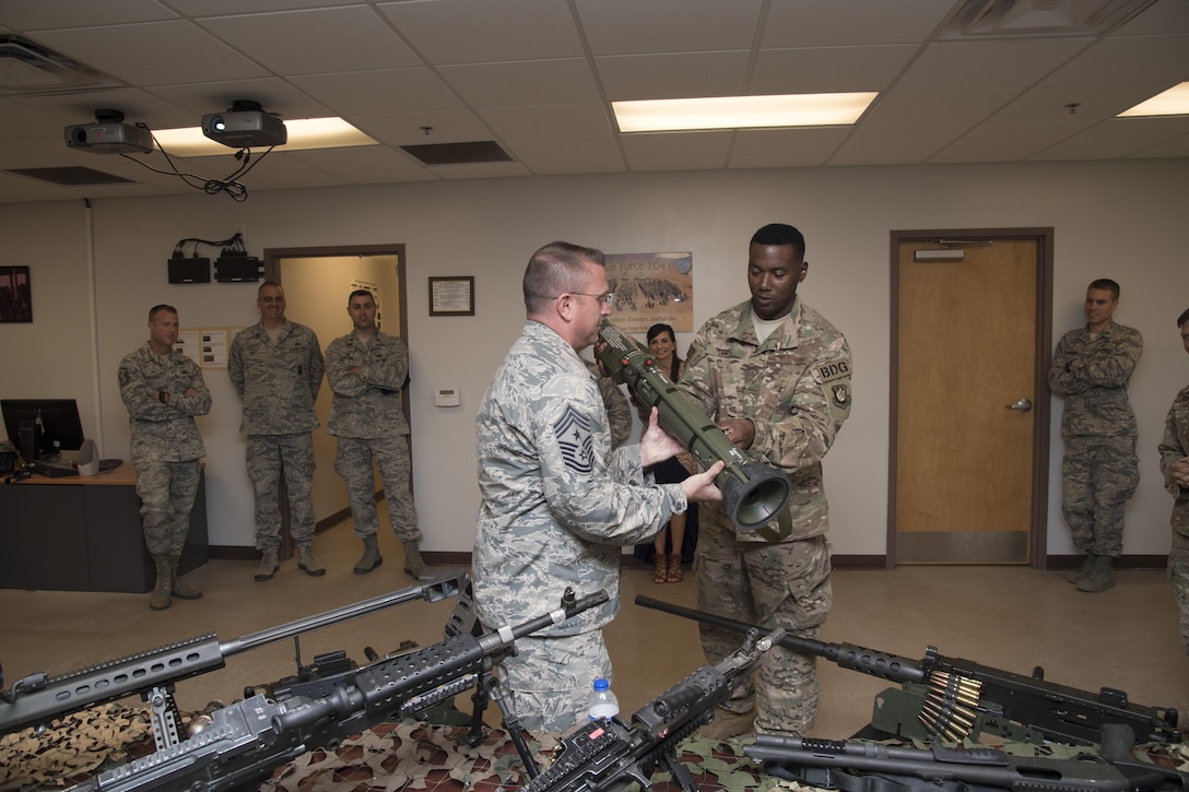 Staff Sgt. Ryan Cox, 823d combat arms training and maintenance instructor, hands Chief Master Sgt. David Wade, 9th Air Force command Chief, an AT4 support weapon during the chief’s visit, July 11, 2017, at Moody Air force Base, Ga.  Wade visited the 93d Air Ground Operations Wing and its units at Moody to learn about the units’ missions and capabilities. (U.S. Air Force photo by Staff Sgt. Eric Summers Jr.)